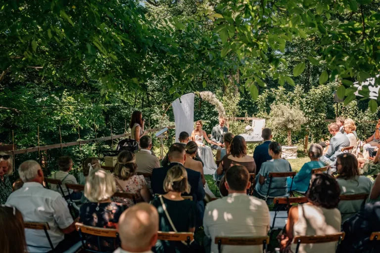 Freie Trauung unter Bäumen im Garten mit Gästen, Brautpaar und Traurednerin Julia Gahlert aus der Oberpfalz